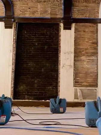 Air movers drying a room with the lower wall opened up