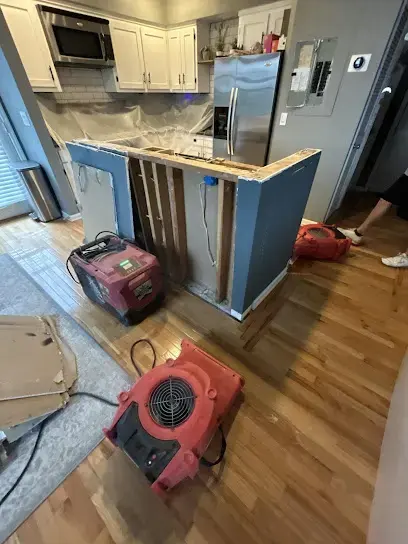 Drying equipment set around a kitchen island after a water leak