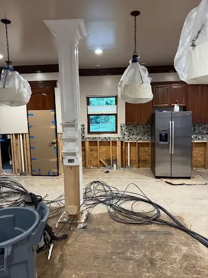 Kitchen opened to the studs with drying lines run across the floor