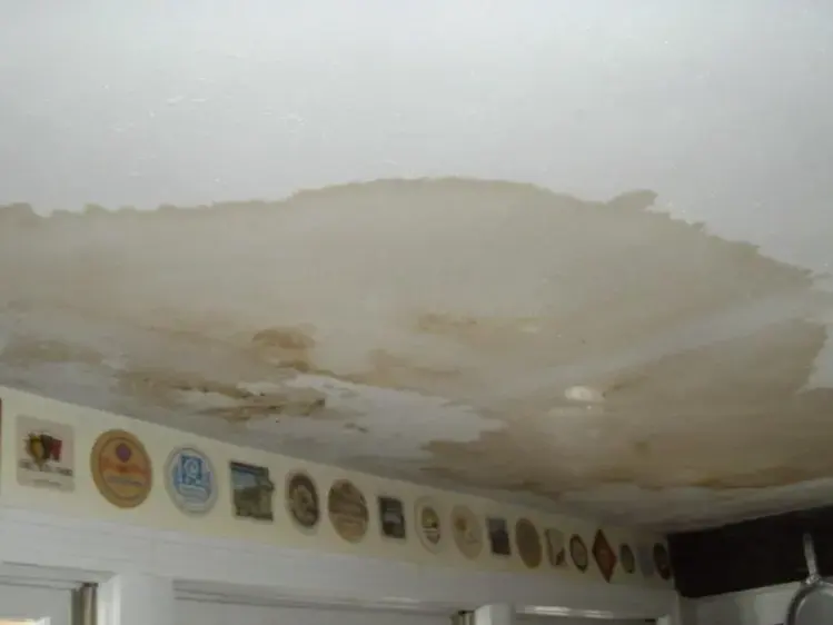Large water stain spreading across a kitchen ceiling from a leak above